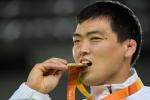 man bites gold medal in celebration 