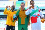 three men stand on a podium with their medals