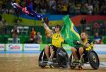 Two men in wheelchairs raise Australian and Brazilian flags. 