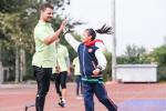 a male Para athlete high fives a girl on the track