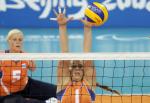 a female sitting volleyball player tries to block a spike