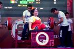 a female powerlifter smiles on the bench