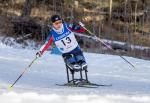 a female Para Nordic skier races towards the finish line