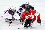 three male Para ice hockey players clash on the ice