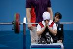 A female powerlifter prays on the bench before a lift