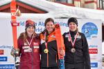 three female alpine skiers standing on the podium