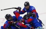 a Para ice hockey team hug in celebration