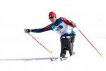 a female sit skier pushes through on the biathlon course