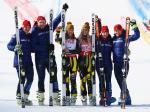 three alpine skiers and their guides on the podium