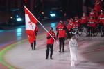 a male Para athlete carrying the Canadian flag