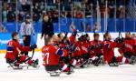 a group of Para ice hockey players celebrating on the ice