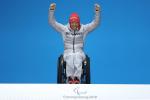 a wheelchair athlete raises her arms on the podium