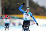 a male Para sit skier crosses the line and celebrates