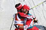 a visually impaired skier and his guide hug on the finish line