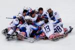 a group of Para ice hockey players in a heap on the ice