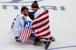 two male Para ice hockey players embrace on the ice
