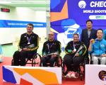 Three shooters in wheelchairs pose on the podium