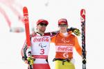 a male vision impaired skier and his guide hug in celebration