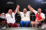three male powerlifters smiling on the podium