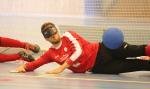 a male goalball player saves a shot