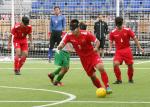 A male blind footballer dribbles past another player
