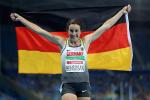 female Para sprinter Irmgard Bensusan holds up a Germany flag in celebration