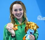 Young woman smiling showing a bronze medal