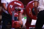 female powerlifter Bose Omolayo prepares to lift the bar
