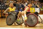 male wheelchair rugby player Ryan Scott chases another player with the ball