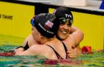 female Para swimmers Maisie Summers-Newton and Ellie Simmonds hug in the pool