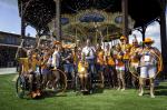 Group photo of Dutch Para equestrian team dressed in orange team colors celebrating with champagne 