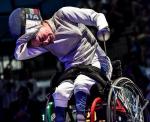 Italian female wheelchair fencer takes off her mask after a win