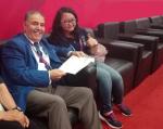 female powerlifting official Meytha Sarasvati gives a thumbs up to the camera