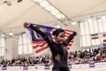 female Para cyclist Nur Azlia Syafinaz Mohd Zais holds up a Malaysia flag