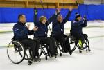 Four Estonian wheelchair curling athletes celebrate a shot on the ice sheet