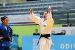 female judoka Alana Maldonado raises her arms to the ceiling in victory
