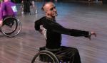 male Para dancer Ivan Sivak raises his arms in a wheelchair