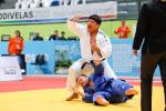 a male South Korean judoka punches the air after throwing his opponent to the ground