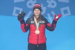 female Para alpine skier Mollie Jepsen raises her arms on the podium 