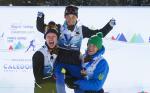 male Para Nordic skier Taiki Kawayoke is held in the air by two other skiers as he raises his arms in celebration