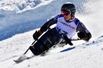 male Para alpine sit skier Jesper Pedersen battles to turn through a gate