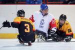 A Czech Para ice hockey player surrounded by two German players