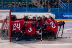 Norwegian Para ice hockey players huddle on an ice rink