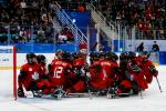 The Canada ice hockey team on sledges on the ice hugging eachother