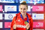 female Para swimmer Elena Krawzow gives a thumbs up and holds up her gold medal 