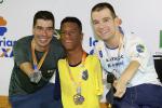 three male Para swimmers with their medals on the podium