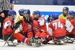 a group of Czech Para ice hockey players hugging on the ice