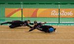 female goalball players Eliana Mason and  Amanda Dennis dive to stop the ball 