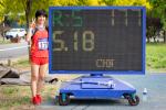 Chinese woman stands next to digital board displaying her world record