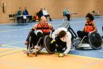 Two men in wheelchair chairs collide playing wheelchair rugby